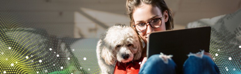 girl working on laptop with dog next to her; moving residential courses online