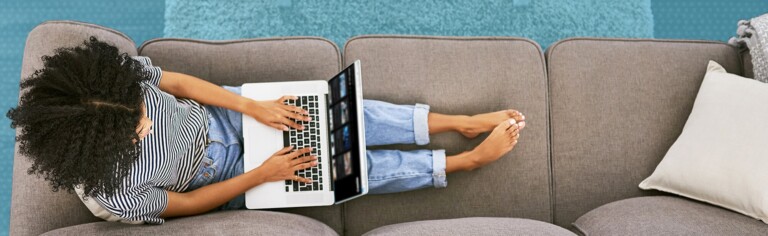 female sitting on couch with laptop; How Technology Enabled a Smooth and Swift Transition to a Fully Virtual Campus [Case Study]