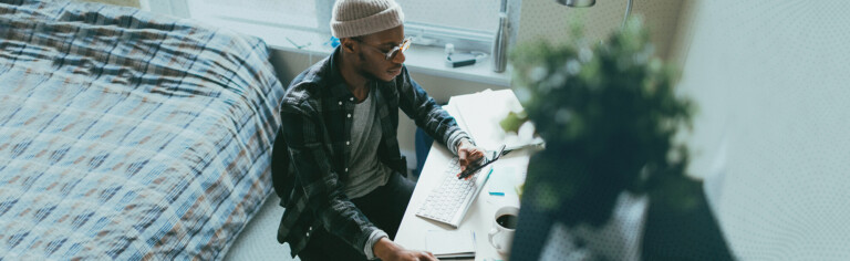 Student attending class online from dorm room; Key Considerations for Hybrid and HyFlex Course Design