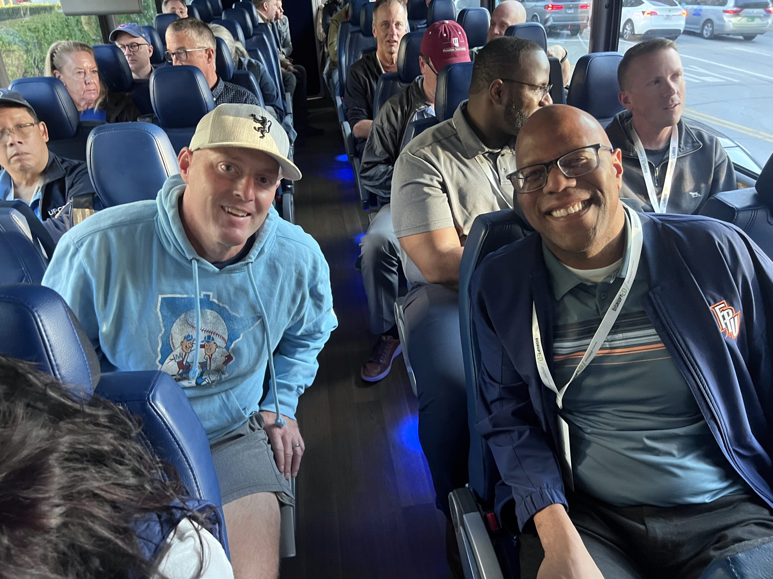 Attendees smiling on bus ride to special event