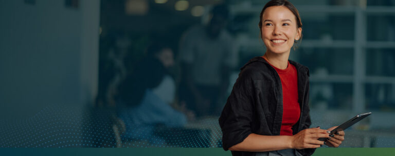Student smiling holding a tablet