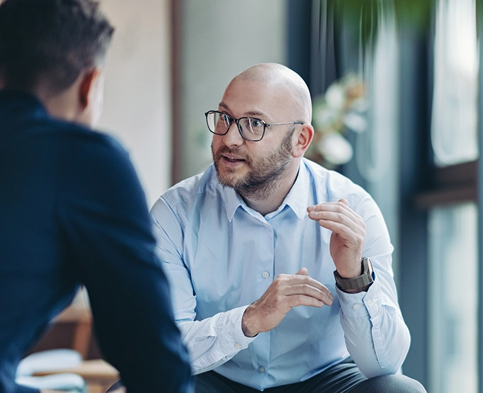 Two higher ed executives conversing in an office setting